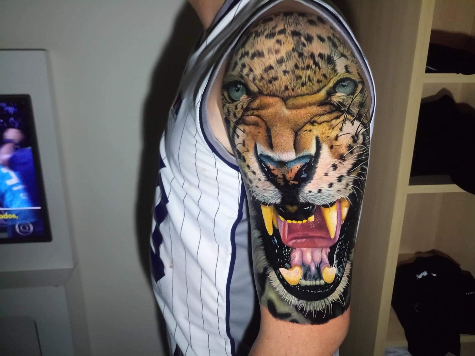 1hj3hkg6_ogj4egeq9fbqvq-1 Braço com tatuagem realista de felino rugindo, exibindo dentes e detalhes faciais.