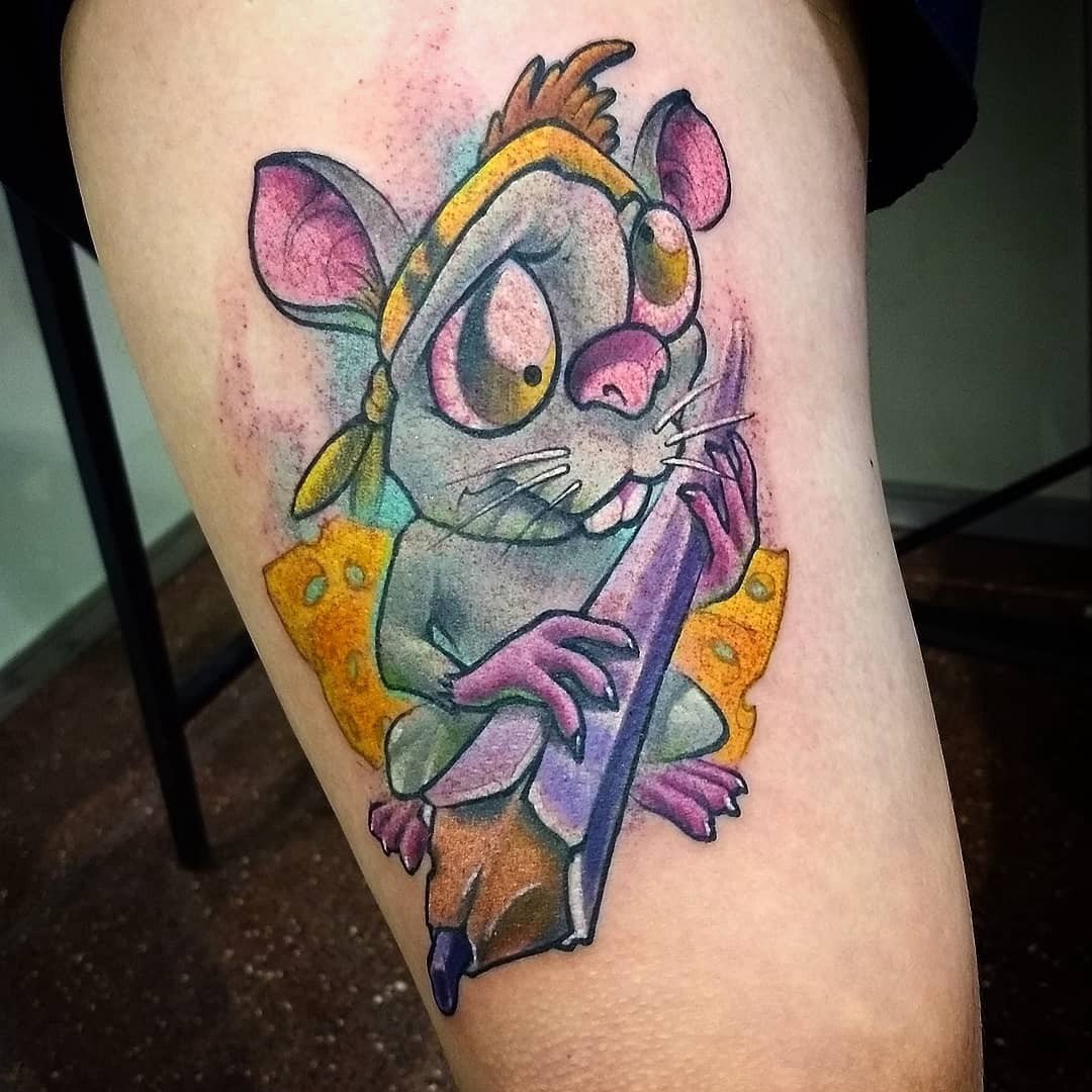 1kyvh2jm0pqizgr2f3yxvaq-1 Tatuagem de um rato colorido segurando um pedaço de queijo, com um olhar expressivo e detalhes vívidos.