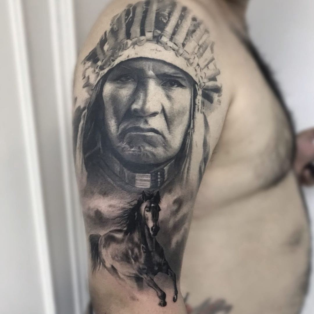 1nbbomdyrrjslfxurazbglg-1 Tatuagem de rosto com cocar e cavalo no braço de uma pessoa.