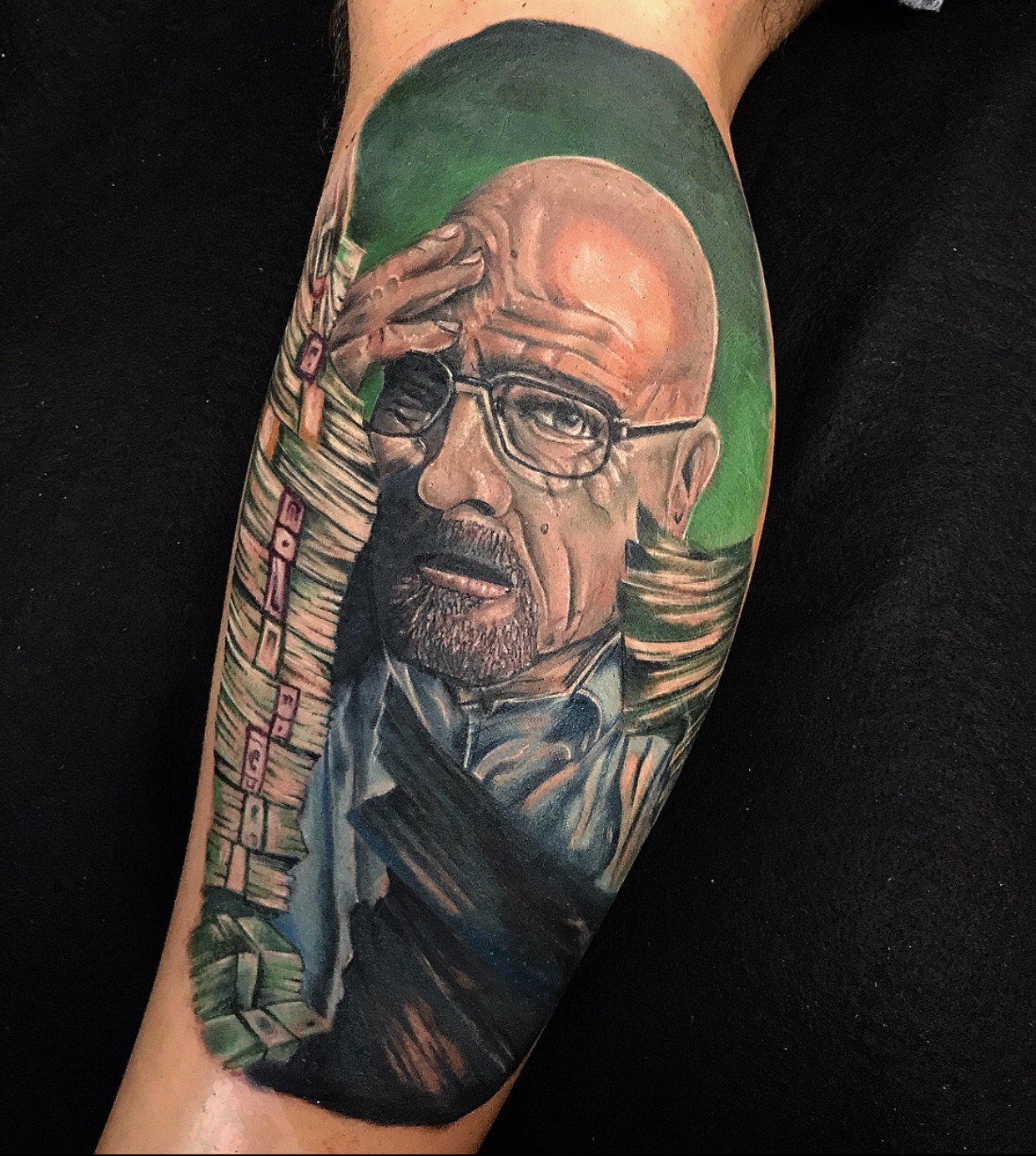 1ts4z51m9xdrnpb9_zqpd7q-1 Tatuagem colorida de um homem careca com óculos, cercado por pilhas de dinheiro, sobre fundo verde.