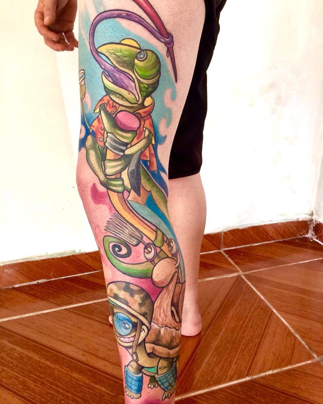 1w7tqjahy91vd50plnwvfha-1 Pessoa com tatuagem colorida na perna, representando um camaleão em um estilo artístico vibrante.