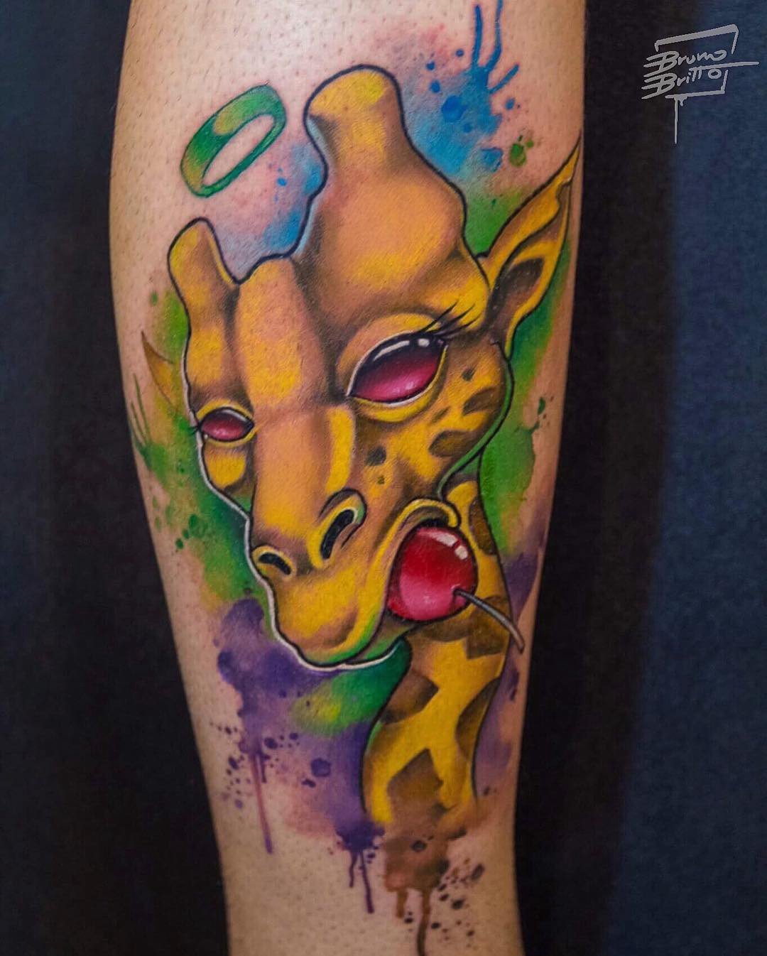 1wzppc8zs4cyagho7dorwrq-1 Uma tatuagem colorida de uma girafa estilizada com um pirulito na boca e um halo acima da cabeça.