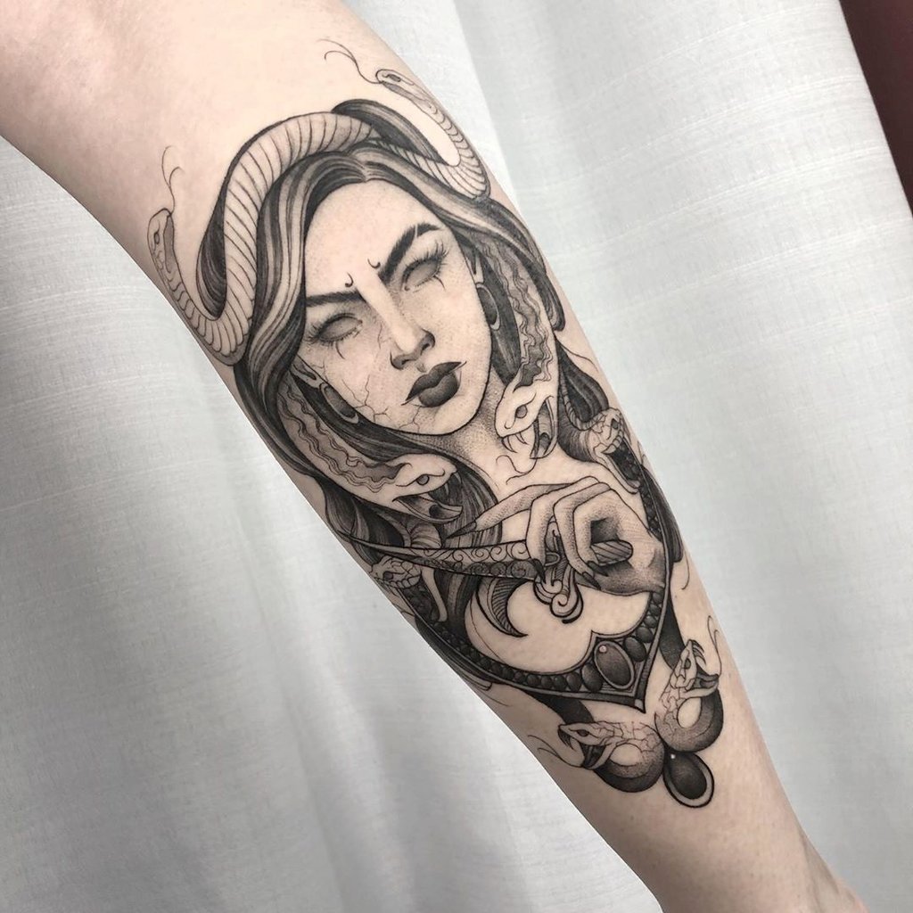 w1024-140 Tatuagem no braço com ilustração detalhada de uma mulher rodeada por cobras, em estilo monocromático.