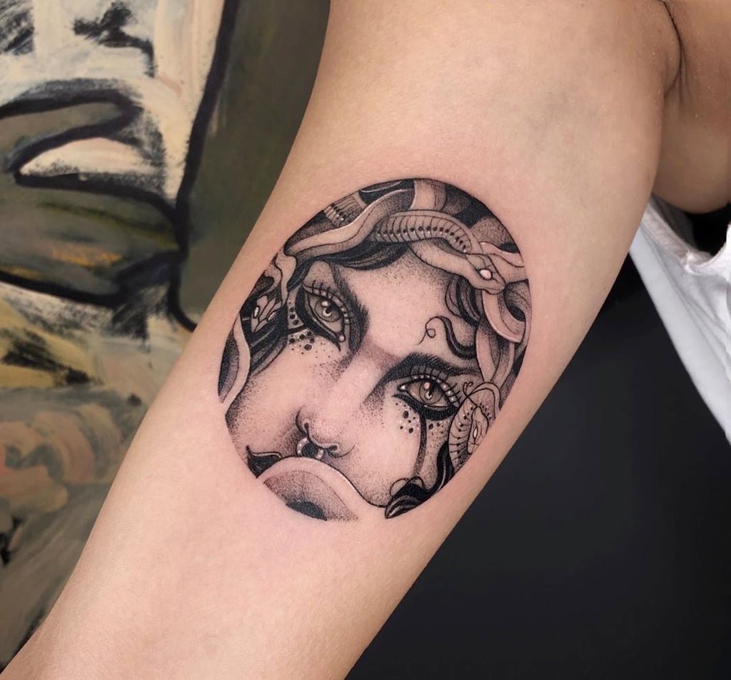 w1024-145 Tatuagem de rosto feminino com cobras no cabelo, estilo monocromático, no braço de uma pessoa.