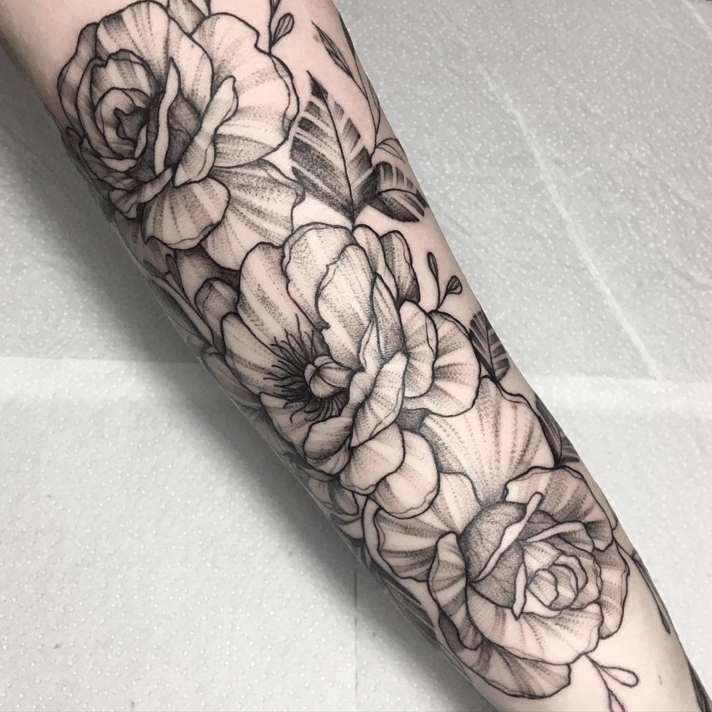 w1024-16 Braço tatuado com flores detalhadas em preto e branco, sobre fundo claro.