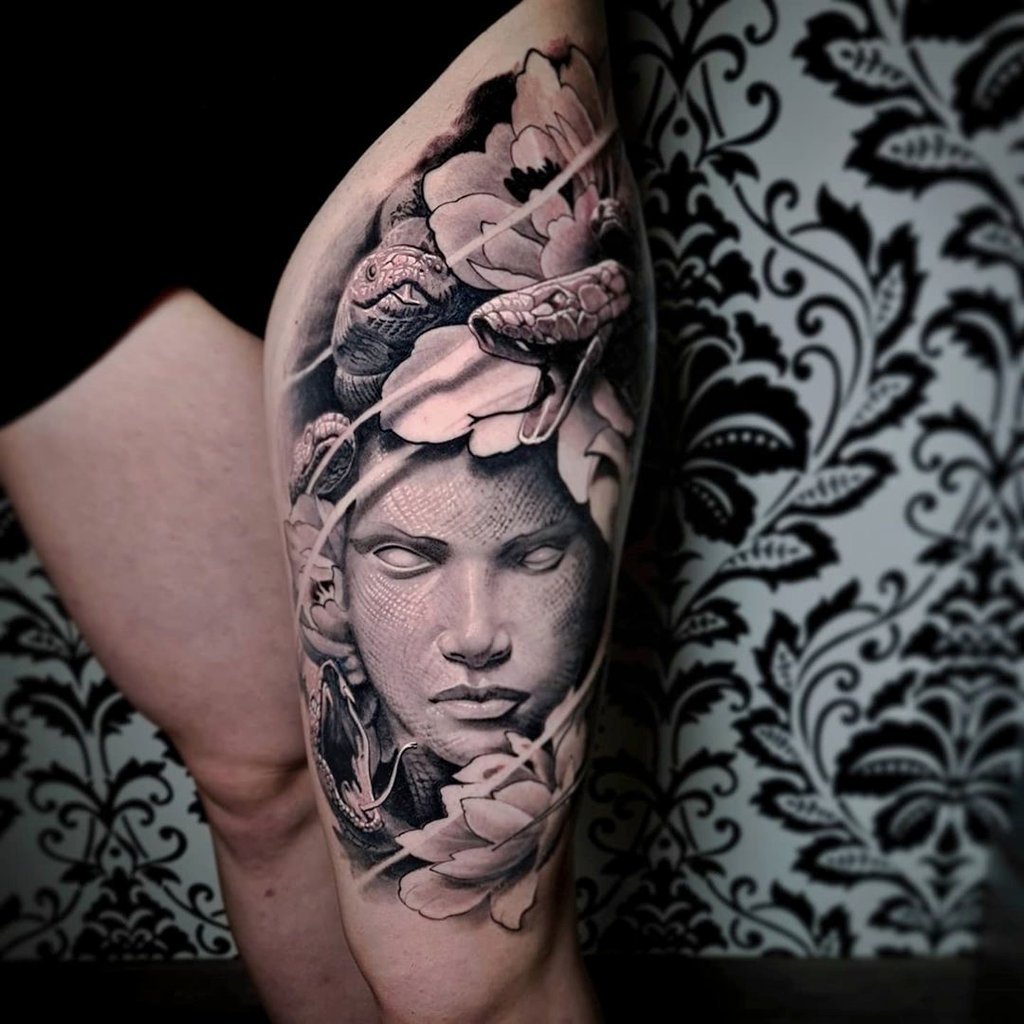 w1024-163 Desenho de tatuagem na perna retratando um rosto cercado por serpentes e flores, com fundo de papel de parede decorativo.