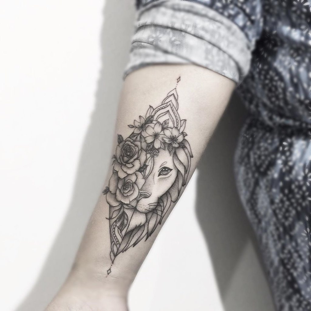 w1024-28 Braço com tatuagem de leão estilizado, adornado com flores e linhas geométricas.