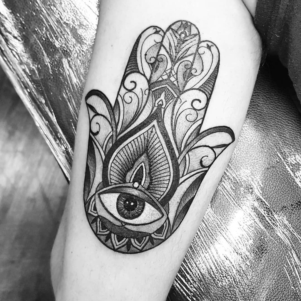 w1024-41 Tatuagem de mão estilizada com um olho central e padrões ornamentais no braço.