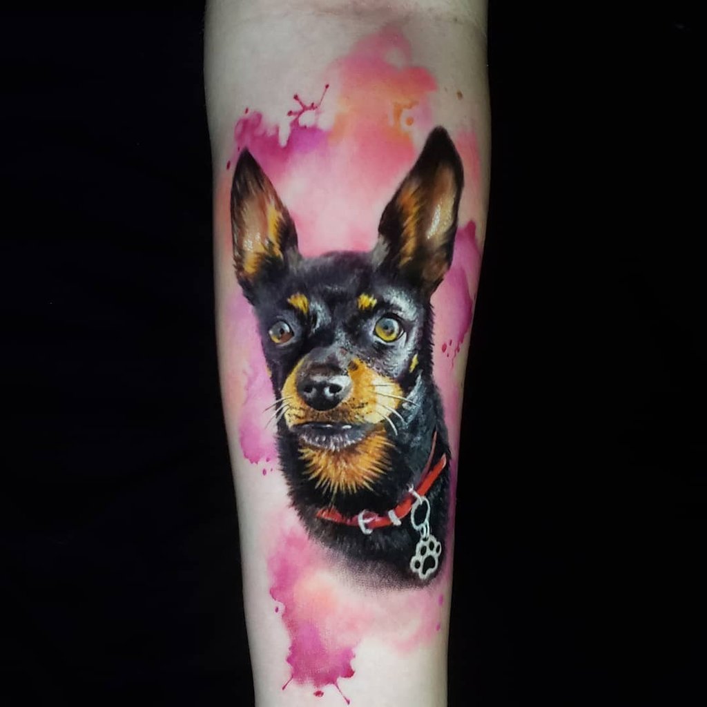 w1024-57 Tatuagem de cachorro preto com fundo colorido em um braço.