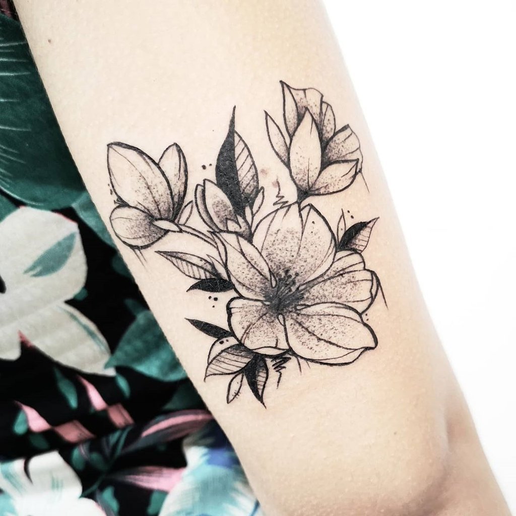 w1024-61 Tatuagem de flores em preto e branco no braço de uma pessoa usando roupa estampada.