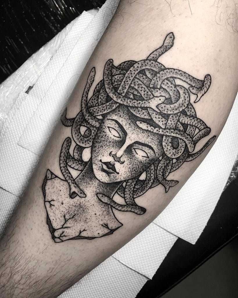 w819-100 Tatuagem de figura mitológica com cobras na cabeça, estilo preto e branco, em um braço.