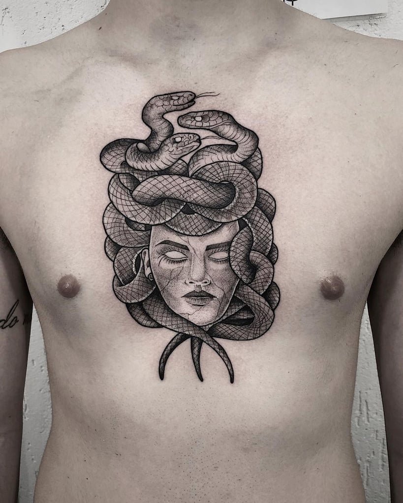 w819-101 Tatuagem no peito de uma figura mitológica com serpentes na cabeça, olhos fechados e expressão serena.