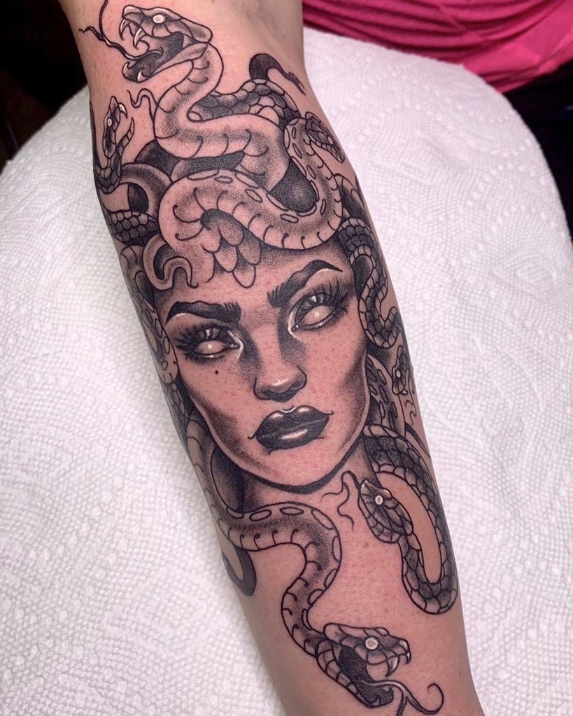 w819-115 Tatuagem de rosto feminino com cobras entrelaçadas no cabelo, sobre a pele do antebraço.