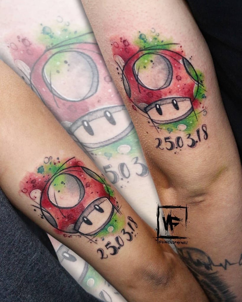 w819-228 Dois braços com tatuagens de cogumelo colorido e data "25.03.18" em estilo aquarela.
