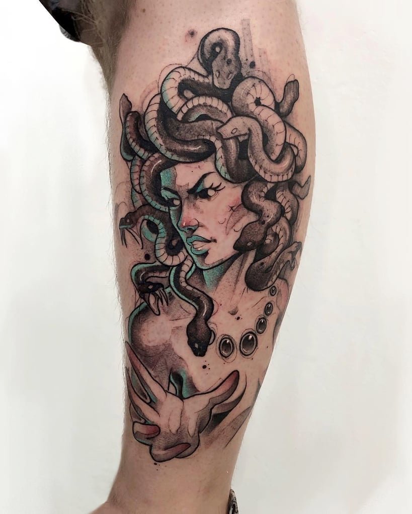 w819-95 Tatuagem de figura mitológica com serpentes no cabelo, em estilo artístico detalhado, no braço de uma pessoa.