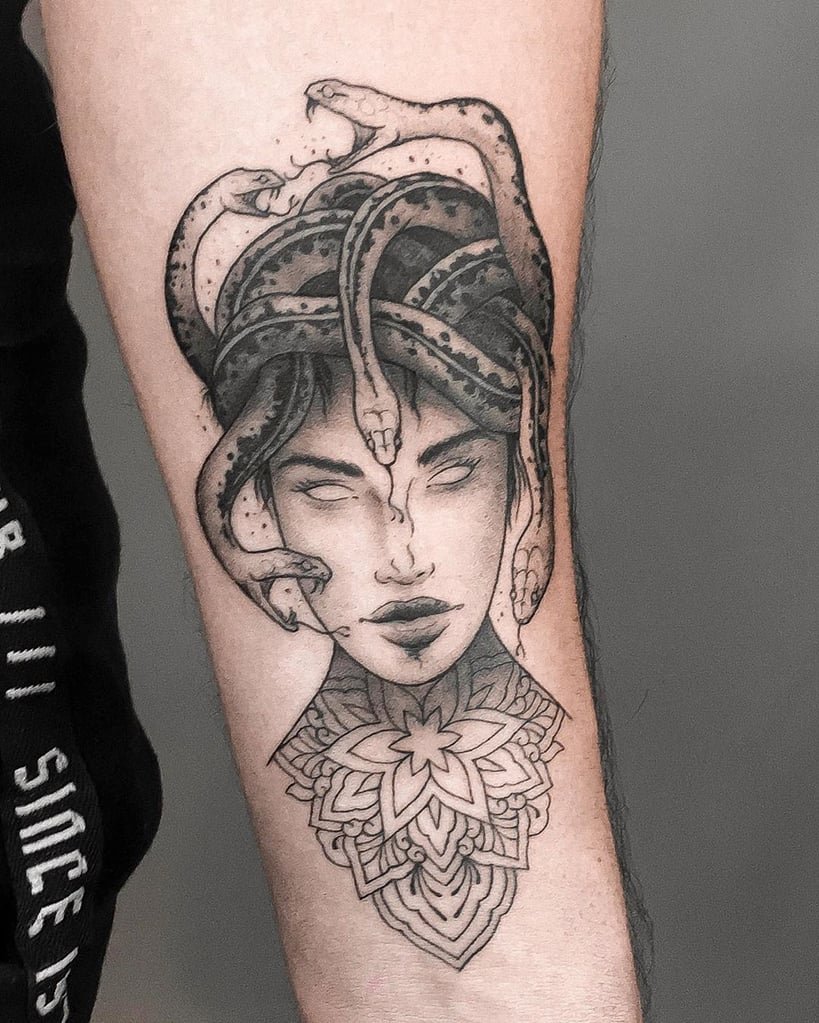 w819-98 Tatuagem de uma figura mitológica com serpentes na cabeça e um padrão geométrico no pescoço.