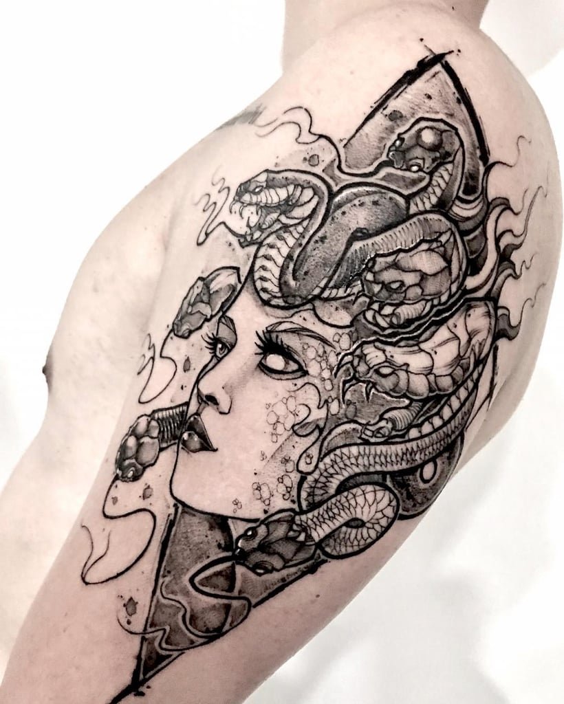w820-5 Braço tatuado com desenho de uma figura mitológica, incluindo rosto feminino e serpentes em estilo artístico detalhado.