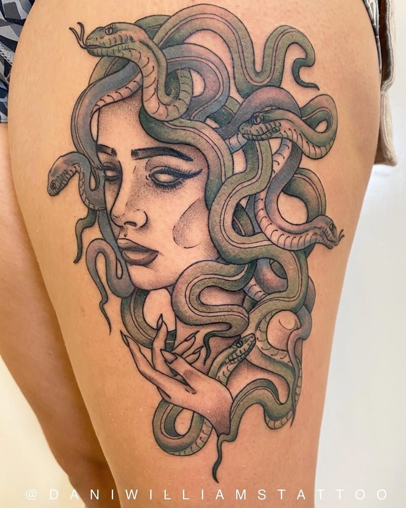 w820-6 Tatuagem de uma figura feminina com cobras entrelaçadas no cabelo, localizada na pele de uma perna.