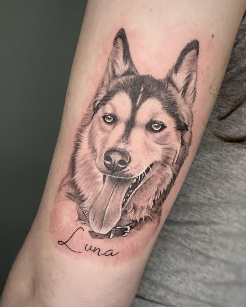 w822-1 Tatuagem realista de cachorro no braço de uma pessoa, com nome "Luna" escrito abaixo.