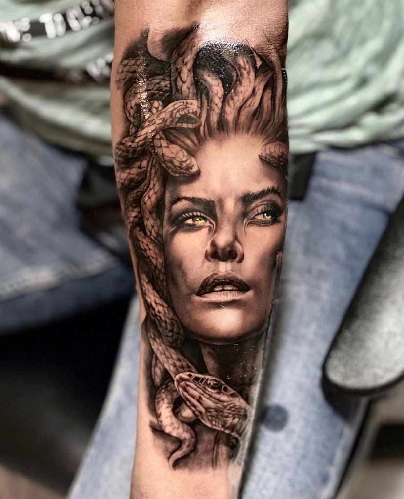 w828-1 Tatuagem em braço de figura mítica feminina com cobras no cabelo, detalhada e realista.
