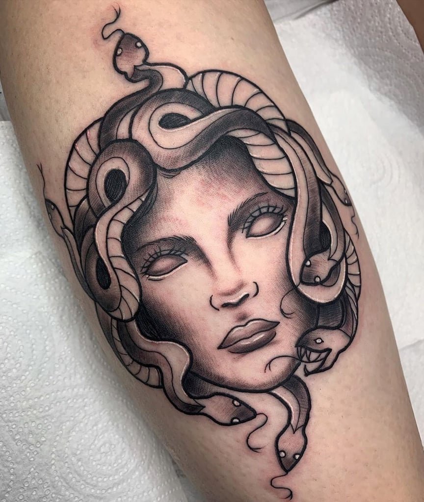 w864 Tatuagem de rosto feminino com cobras no cabelo, estilo mitológico, em tons de preto e cinza.