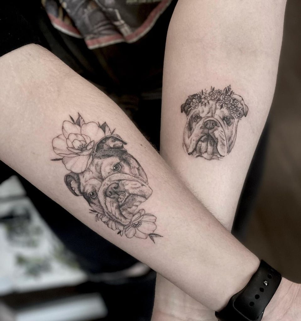 w958-2 Dois antebraços com tatuagens de cachorros decorados com flores.