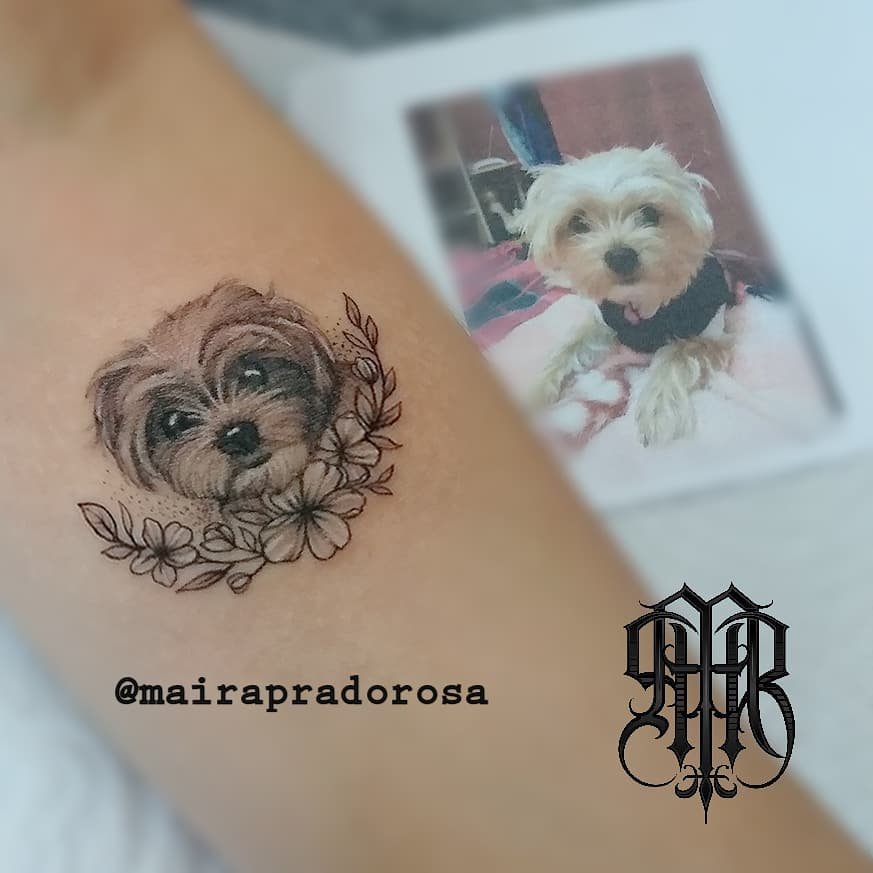 w9999-5 Uma tatuagem de rosto de cachorro com flores no braço, ao lado de uma foto do mesmo cachorro.