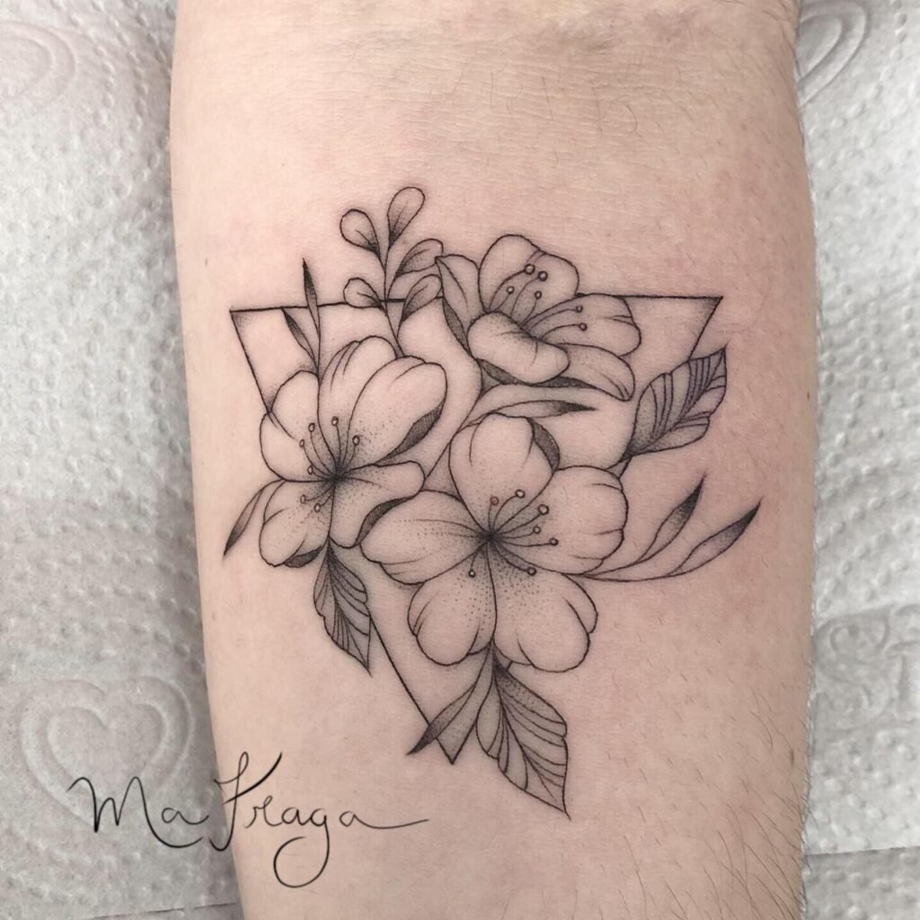 Tatuagem de flores delicadas em preto e branco sobre o braço com design geométrico.