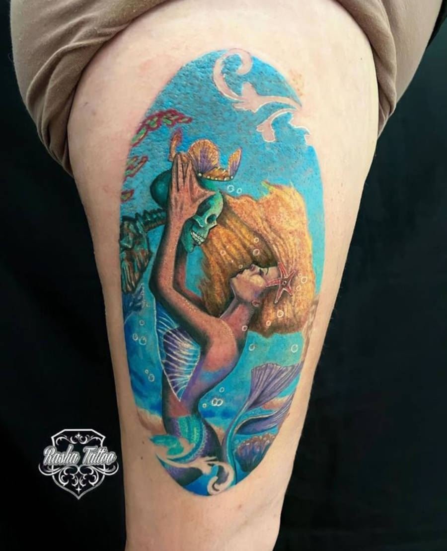 Foto de sereia beijando caveira em uma tattoo colorida