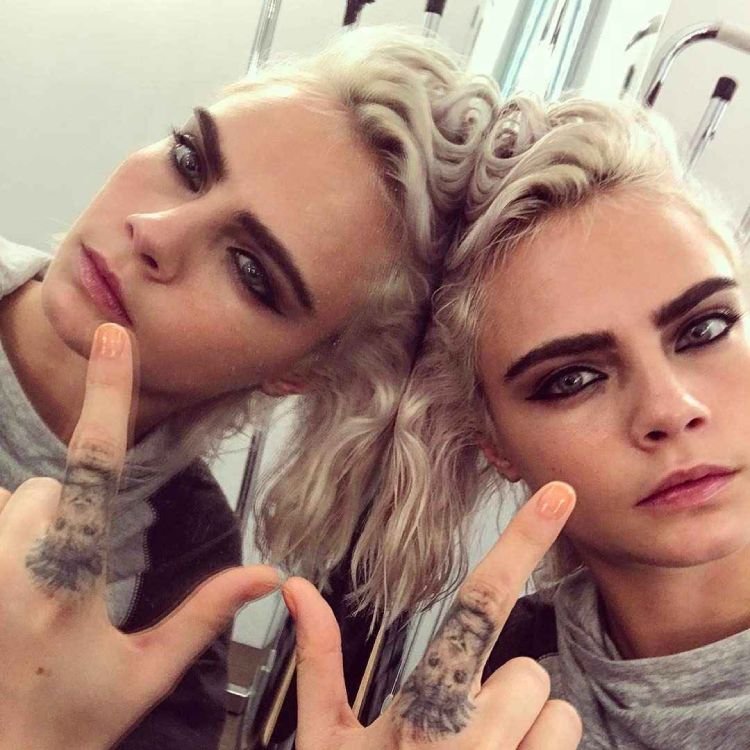Cara Delevigne com tatuagem de leão no dedo