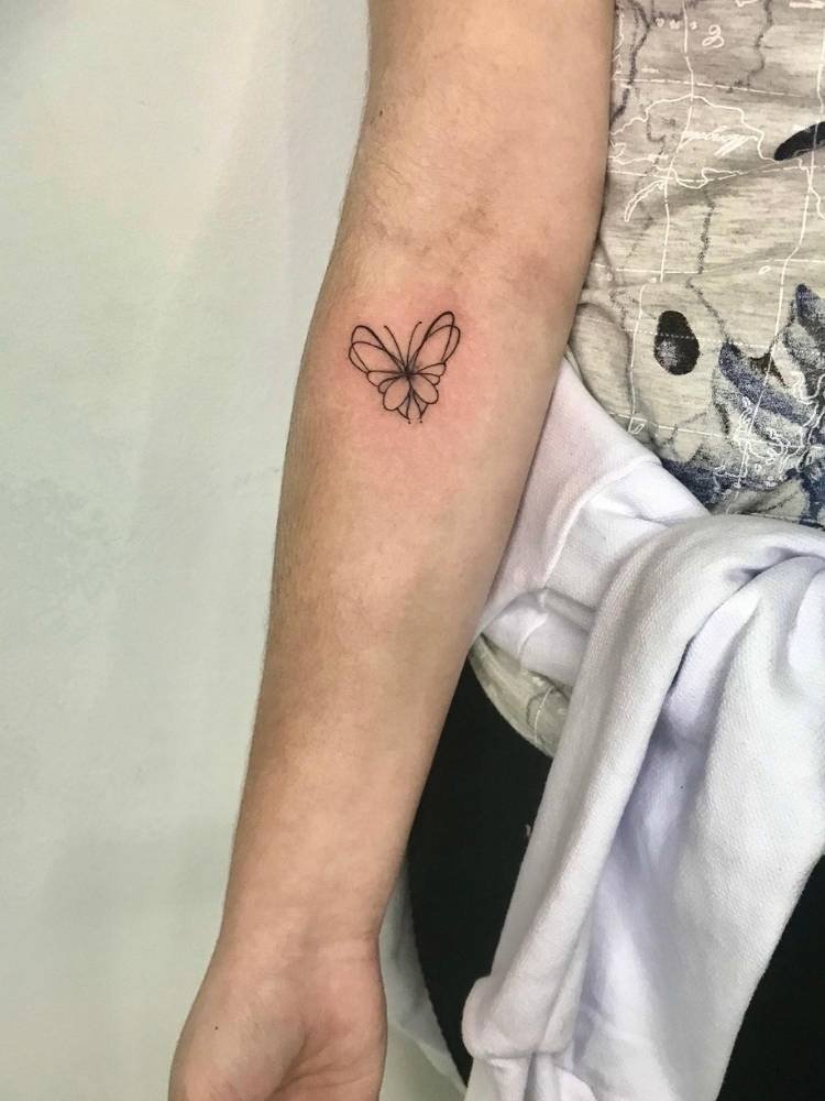delicada-borboleta Tatuagem de borboleta delicada com poucos traços, sendo eles finos e pretos, pequena e minimalista. Feita no braço de uma mulher de pele clara.