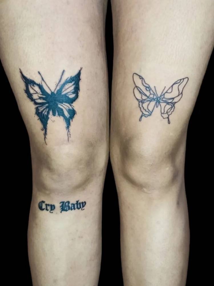 dupla-tattoo-borboleta Tatuagem de duas borboletas, uma acima de cada joelho de uma mulher de pele clara. Uma delas apresenta traços grossos, muito uso da tinta preta e a outra é mais delicada, com traços mais finos e sem sombreamento,