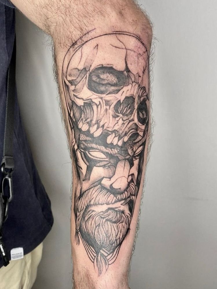 imagem-32 foto de tatuagem de caveira e feição masculina pelo antebraço.