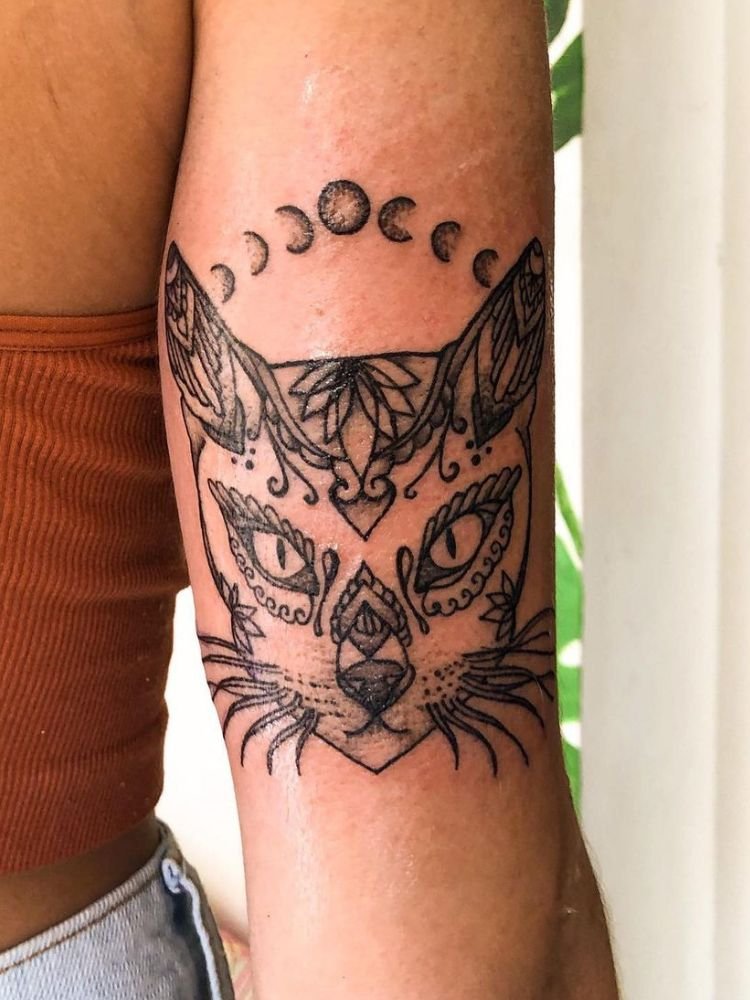 imagem-35 tatuagem de gato com fases da lua, no tríceps.