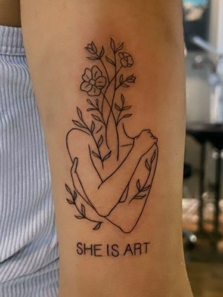 imagem-40-2 tatuagem no braço com a frase "she is art" e um tronco se abraçando.
