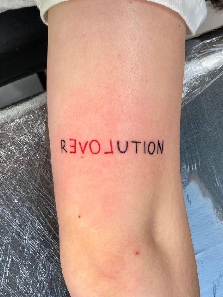 imagem-43-1 tatuagem com a palavra "revolution".