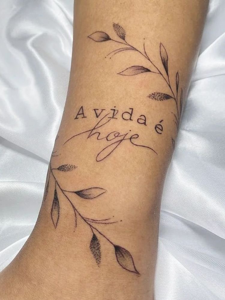 imagem-44-1 tatuagem com a frase "a vida é hoje" e um ramo de planta.