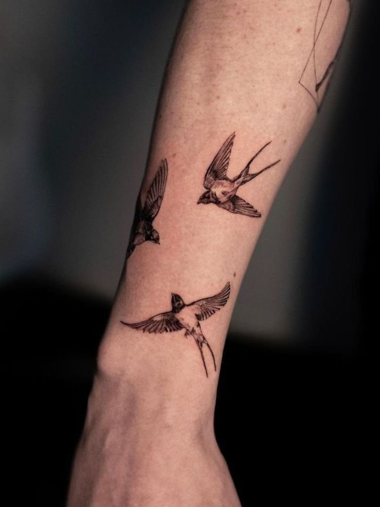 imagem-50 tatuagem de três pássaros feita próximo ao pulso.