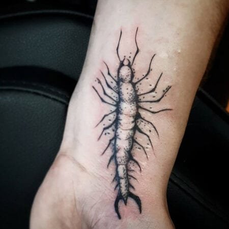 Tattoo de centopéia cobrindo cicatriz pulso