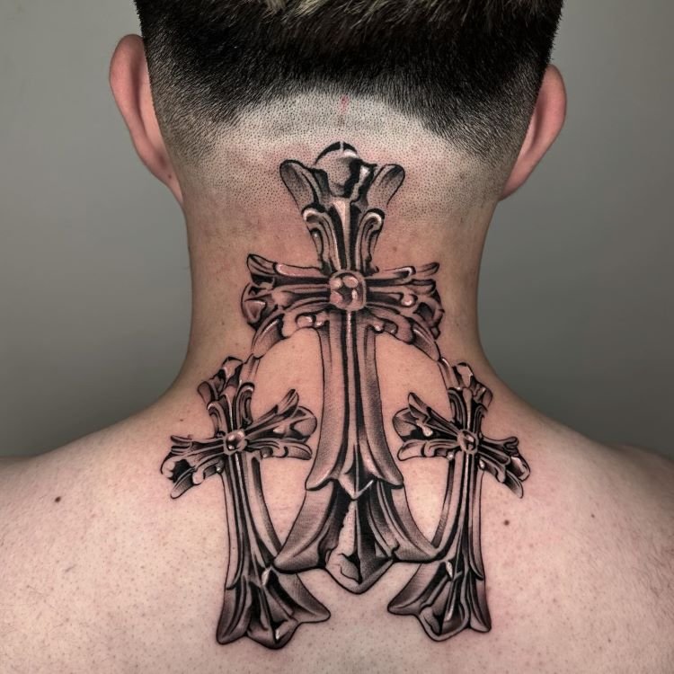 tatuagem-de-cruz-no-pescoco-8-1 A imagem mostra uma pessoa de costas com cabelo curto. Ela tem uma tatuagem no pescoço de três cruzes ornamentadas, detalhadas em preto e cinza. A maior cruz está no centro, com duas menores em cada lado, cobrindo toda a parte de trás do pescoço até os ombros.