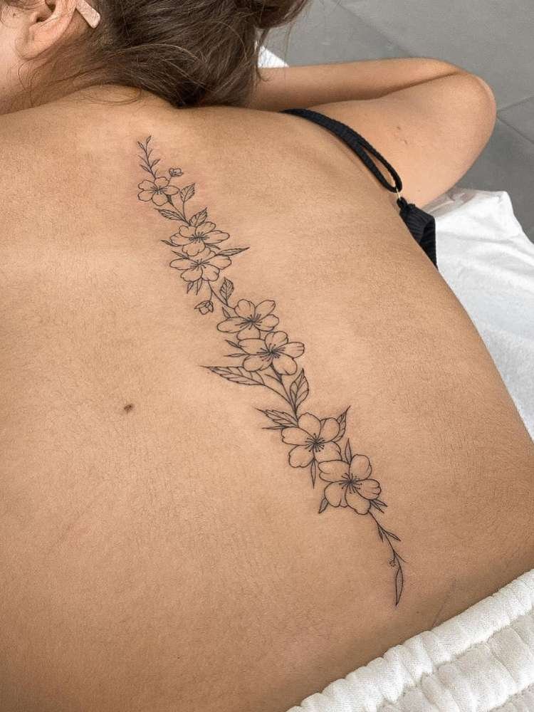 Mulher exibe tatuagem de flor