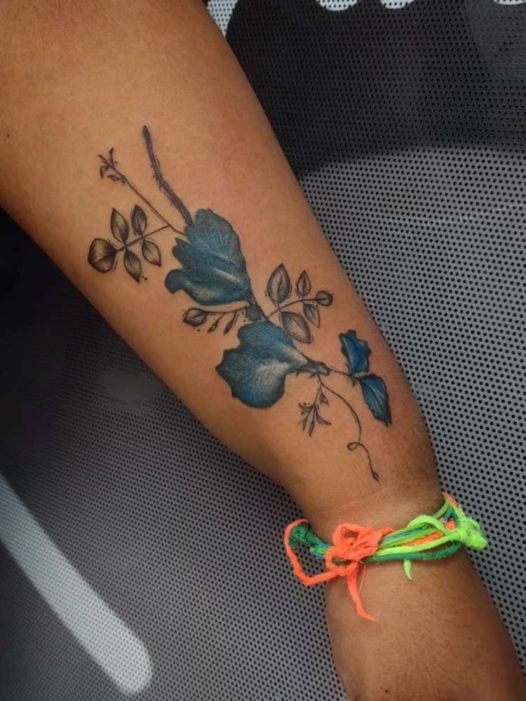 Mulher exibe tatuagem de flor