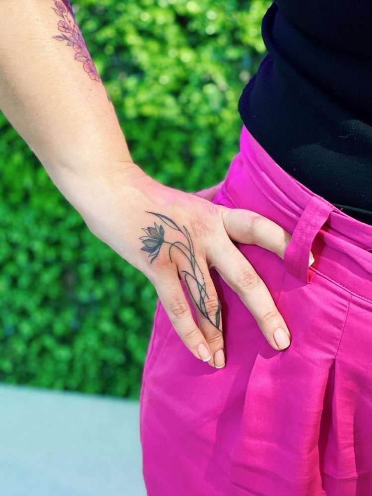 Mulher exibe tatuagem de flor