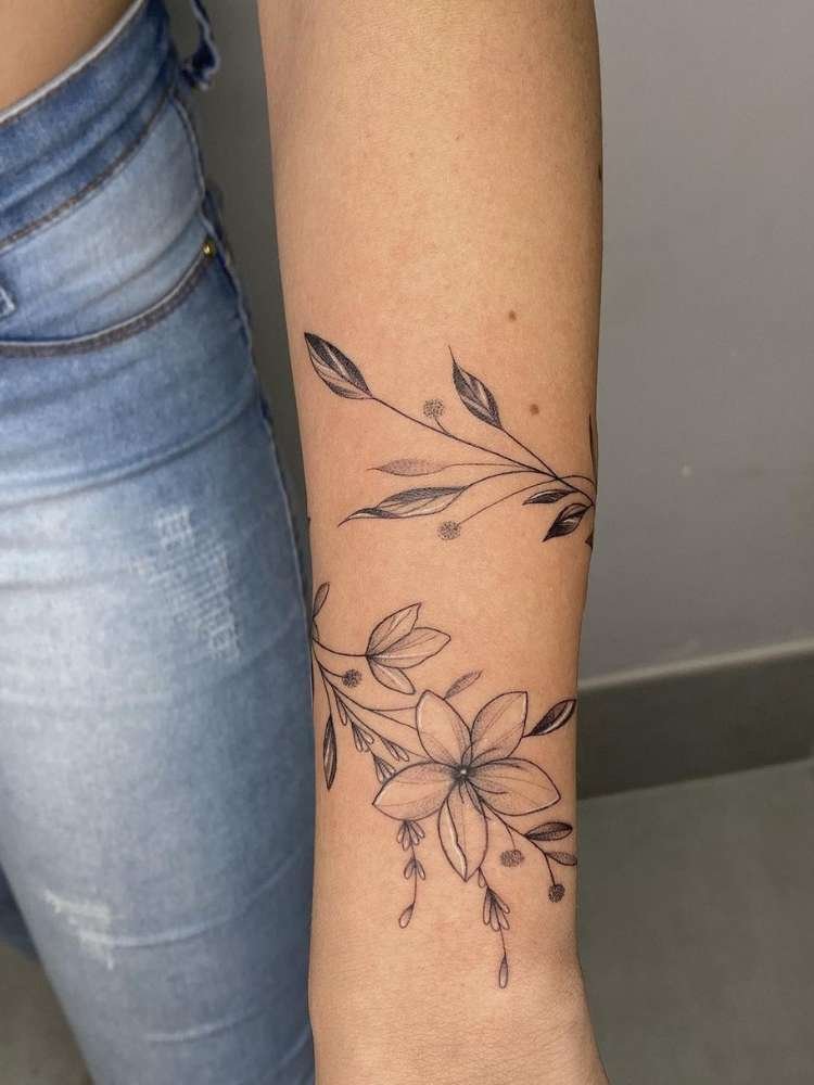 Mulher exibe tatuagem de flor