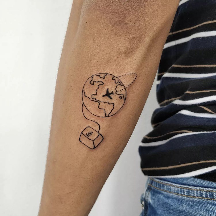 Tatuagem de viagem no braço de mundo com avião e tecla ESC