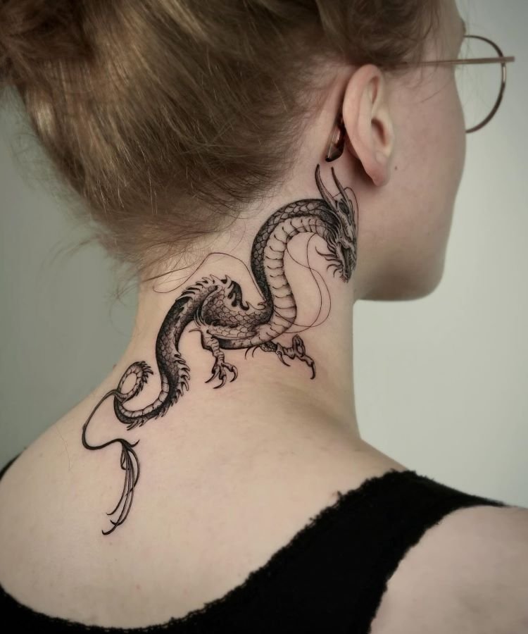 tatuagem-feminina-no-pescoco-6-1 A imagem mostra uma pessoa de perfil com cabelo preso e óculos. Ela tem uma tatuagem no pescoço de um dragão detalhado em preto, que se estende da parte de trás da orelha até a base do pescoço. A tatuagem é intrincada, com escamas e garras bem definidas.