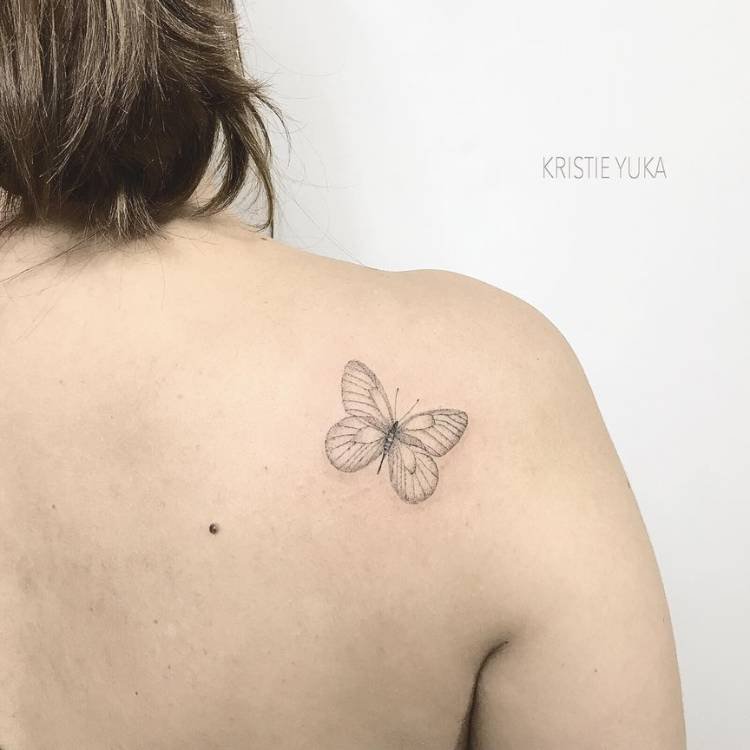 tatuagem-feminina-ombro-borboleta-delicada-atras Mulher de pele clara e cabelo curto de costas com tatuagem delicada fine line de borboleta