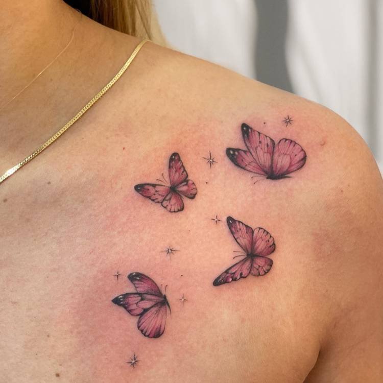 tatuagem-feminina-ombro-borboleta-rosa Mulher de pele clara com ombro tatuado com 4 borboletas rosas
