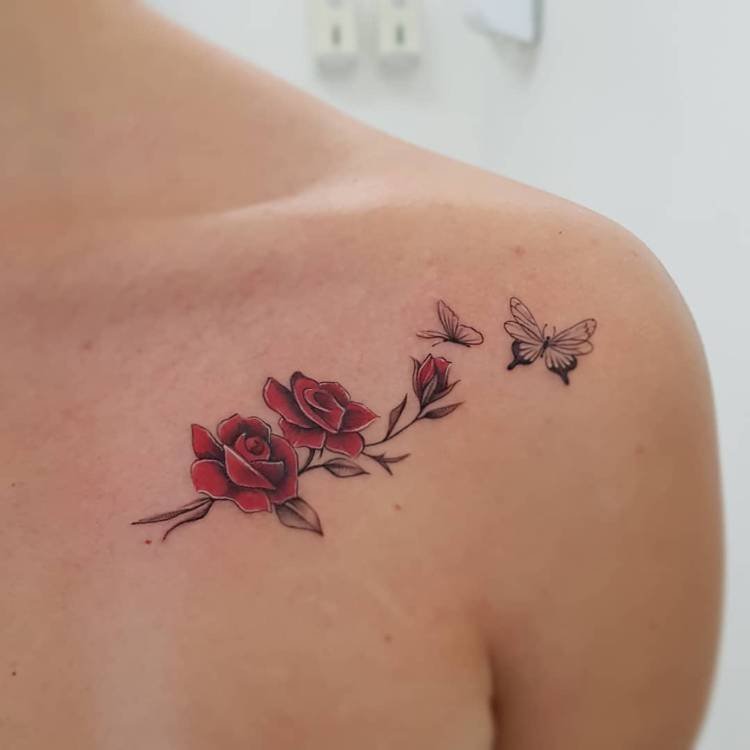 tatuagem-feminina-ombro-flor-vermelha-borboleta Mulher de pele clara com tatuagem de rosas vermelhas e borboletas delicadas no ombro