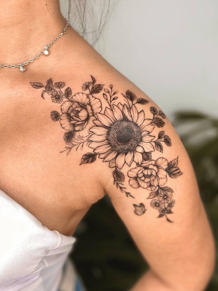 tatuagem-feminina-ombro-girassol Mulher de pele clara e cropped branco com tatuagem de girassol sombreada no ombro